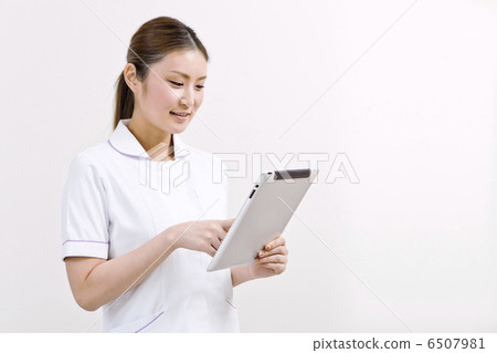 A lady in a white garment with a tablet terminal A lady in a white garment with a tablet terminal 6507981
