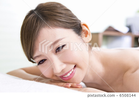 A lady with a smiling face lying face down A lady with a smiling face lying face down 6508144