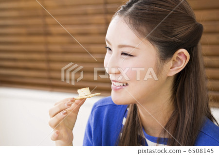 A woman eating hors d'oeuvres A woman eating hors d'oeuvres 6508145