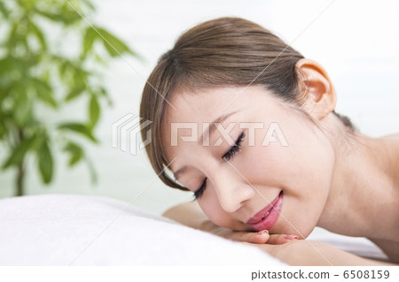 A woman closing her eyes with her face lying down A woman closing her eyes with her face lying down 6508159