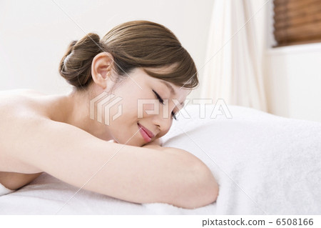 A woman closing her eyes with her face lying down A woman closing her eyes with her face lying down 6508166