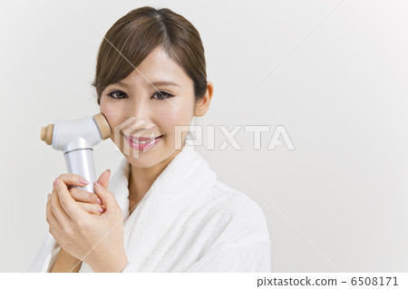 A woman using a facial instrument 6508171