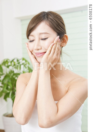 A woman touching her cheeks with both hands A woman touching her cheeks with both hands 6508178