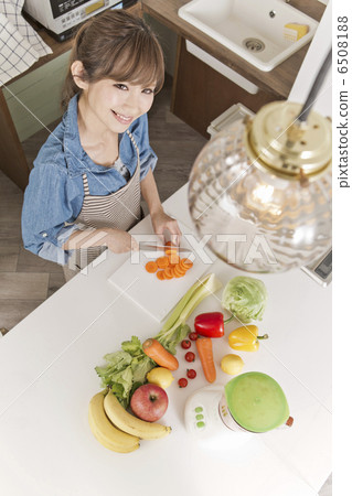 A woman cutting carrots with a kitchen knife A woman cutting carrots with a kitchen knife 6508188