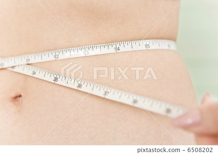 A woman measuring a waist size with a measure 6508202