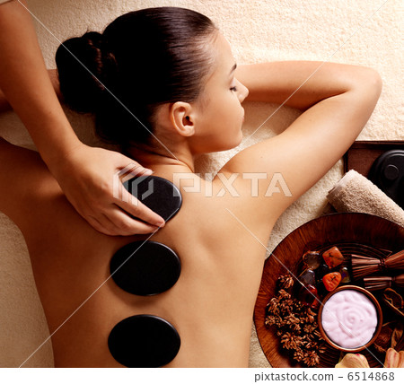 Woman getting hot stone massage in spa salon. 6514868