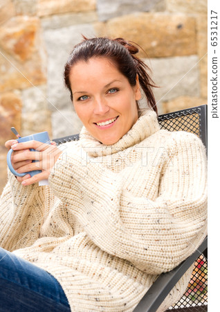 Smiling woman drinking hot cocoa relaxing garden Smiling woman drinking hot cocoa relaxing garden 6531217