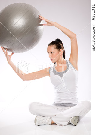 Slim young woman exercising from sitting position Slim young woman exercising from sitting position 6531311