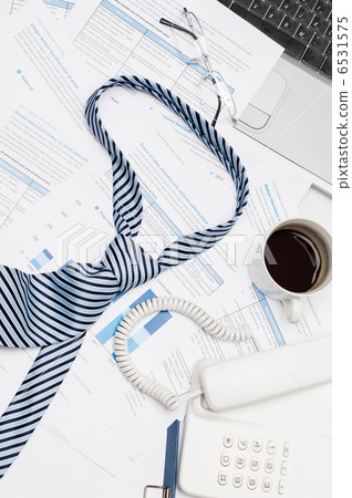 Busy office desk tie on paper charts Busy office desk tie on paper charts 6531575
