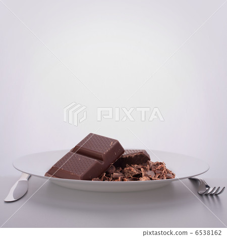 Chocolate bars stack on plate. 6538162