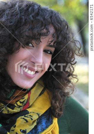 Young curly woman smiling Young curly woman smiling 6542171