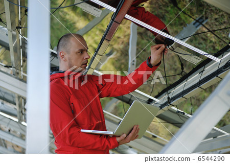 engineer using laptop at solar panels plant field engineer using laptop at solar panels plant field 6544290