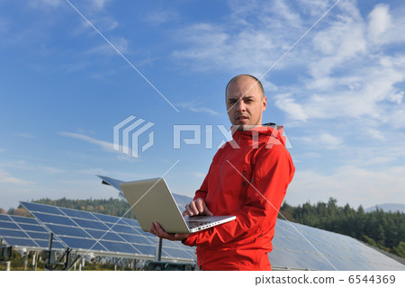 engineer using laptop at solar panels plant field engineer using laptop at solar panels plant field 6544369