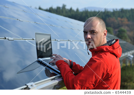 engineer using laptop at solar panels plant field engineer using laptop at solar panels plant field 6544439