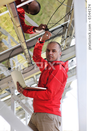 engineer using laptop at solar panels plant field engineer using laptop at solar panels plant field 6544574