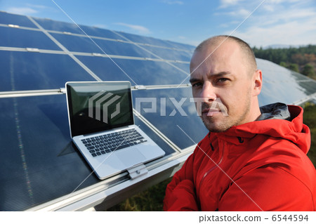 engineer using laptop at solar panels plant field engineer using laptop at solar panels plant field 6544594