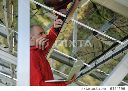 engineer using laptop at solar panels plant field engineer using laptop at solar panels plant field 6544596