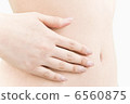 Hand of a woman's hand on her stomach 6560875