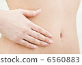 Hand of a woman's hand on her stomach 6560883