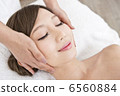 A woman receiving facial beauty treatment 6560884