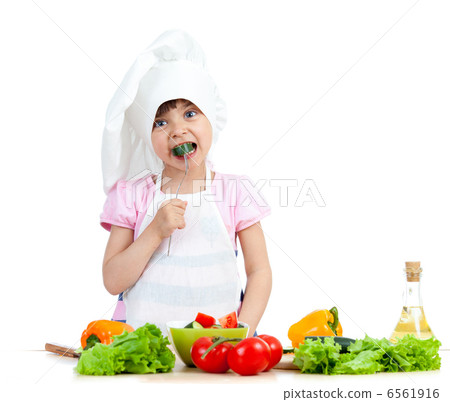 Chef kid preparing and tasting healthy food over white backgroun 6561916