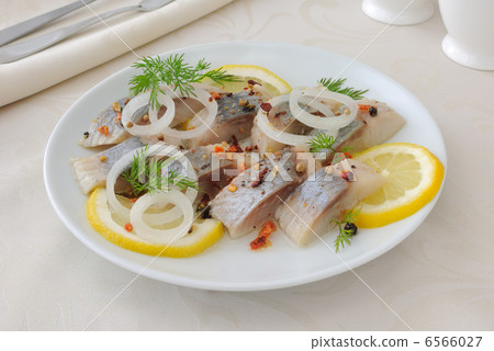 Slices of salted herring with onion, lemon and spices 6566027