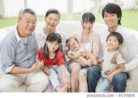 Three generations family sitting on the sofa in the living room 6570806