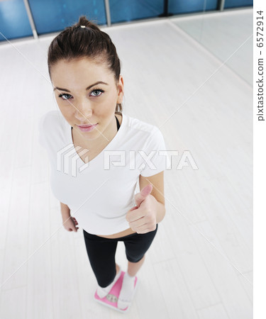 happy diet concept with young woman on pink scale happy diet concept with young woman on pink scale 6572914