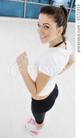 happy diet concept with young woman on pink scale 6572919