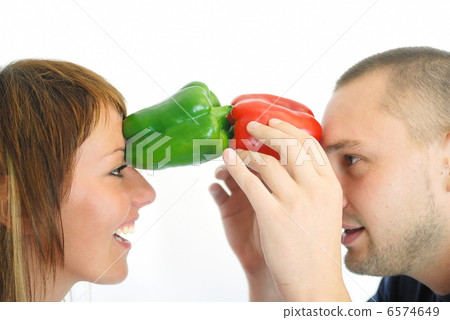 happy couple holding peppers with head 6574649