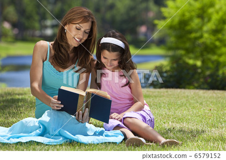 Woman and Girl, Mother and Daughter, Reading a Book Together Out 6579152