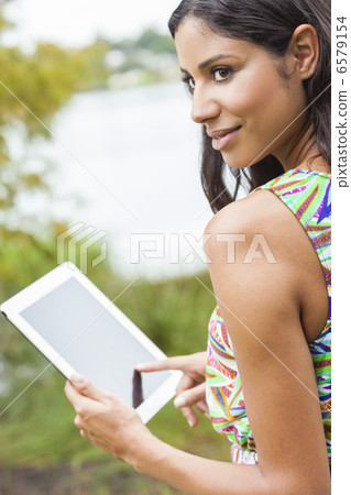 Mixed Race Latina Woman Using Tablet Computer Mixed Race Latina Woman Using Tablet Computer 6579154