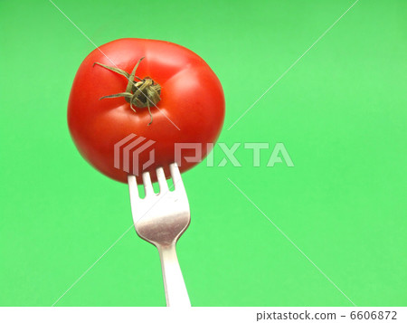 fresh tomato on fork with green background fresh tomato on fork with green background 6606872