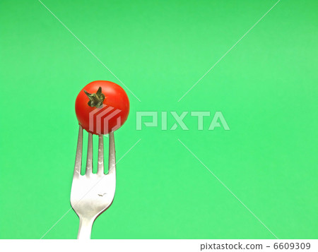 fresh tomato on fork with green background fresh tomato on fork with green background 6609309