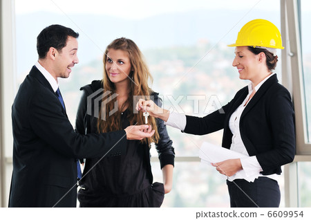happy young couple buying new home with real estate agent 6609954