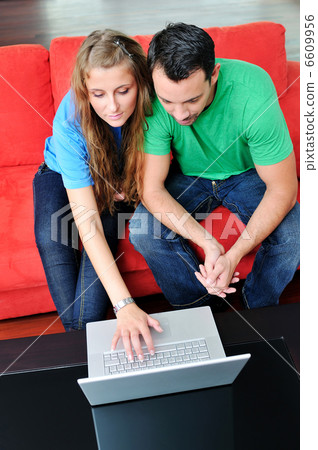 happy couple have fun and work on laptop at home 6609956