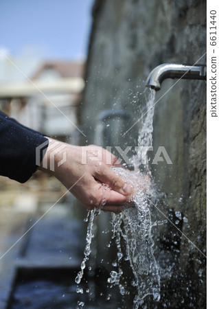 fresh mountain water falling on hands 6611440