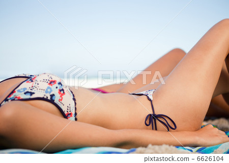 Side view of a young woman bikini on the beach 6626104