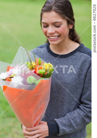 Smiling teenage receiving a bunch of flowers Smiling teenage receiving a bunch of flowers 6627028