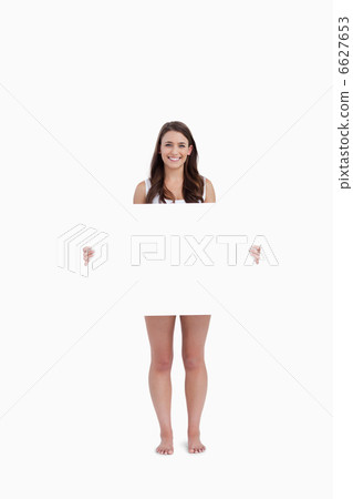 Smiling brunette holding a blank poster 6627653