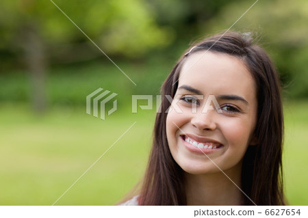 Young smiling woman looking at the camera while standing up in a 6627654