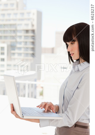 Woman at work using her laptop 6628237
