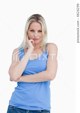 Thoughtful blonde woman placing a finger on her cheek 6628299