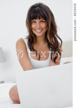 Happy young woman using her laptop Happy young woman using her laptop 6629439