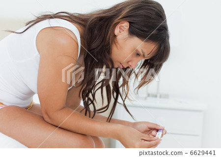 Worried young woman looking a pregnancy test 6629441