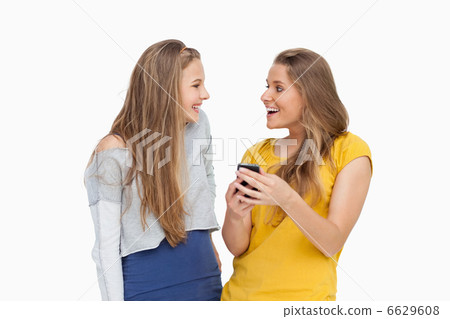Two happy young women looking a smartphone Two happy young women looking a smartphone 6629608