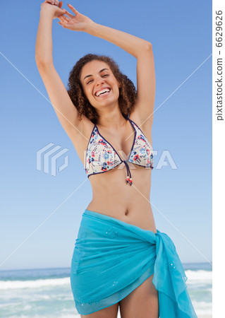 Smiling young woman raising her arms to show her happiness 6629626