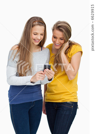 Two females student smiling while looking a cellphone 6629915