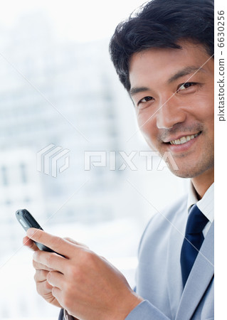 Portrait of a office worker using his mobile phone Portrait of a office worker using his mobile phone 6630256