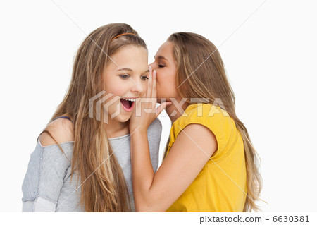 Young woman whispering to her friend Young woman whispering to her friend 6630381
